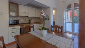 A kitchen with a dining table, chairs, a microwave, and a potted plant. - GuestHost - Manfredini Historical House in the heart of Ferrara (Ferrara)