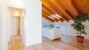 Een moderne keuken met houten balken, een centraal eiland en een plant in pot.