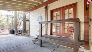 Un banco de madera frente a un edificio con una puerta roja y una ventana que dice "Coffee".
