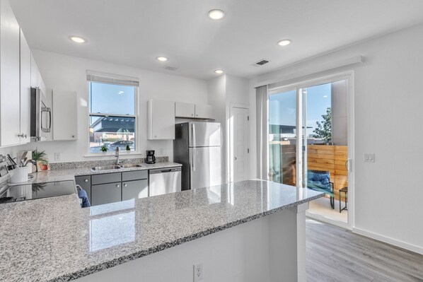 Een koelkast, een vaatwasser, kookgerei, borden en bestek, keukenpapier