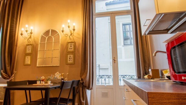 A dining area with a table, chairs, and a view through a door to the outside. - Atriums Apartment Quovis Domus, an enchanting nest in the heart of city centre (Torino)