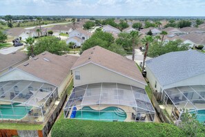 Un barrio residencial con varias casas, una piscina y un espacio exterior cubierto.