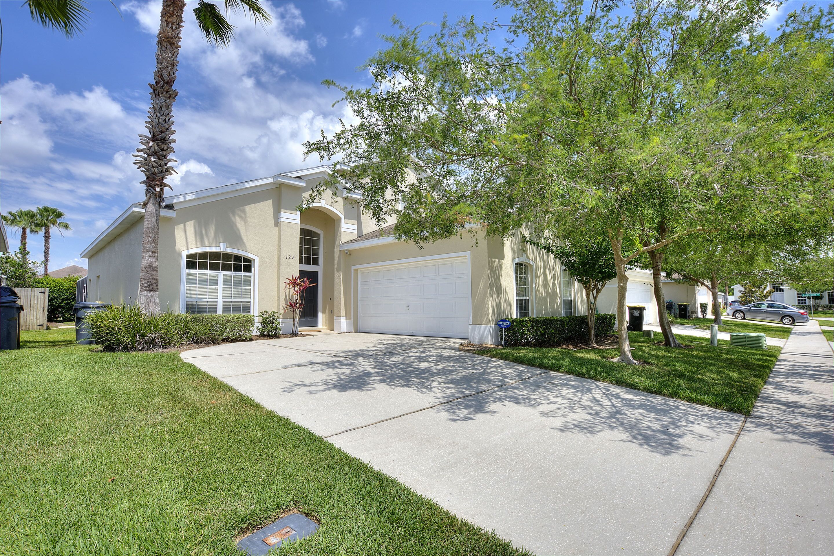 A residential house with a garage, a well-maintained lawn, and a clear sky.
