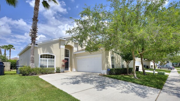 A residential house with a garage, a well-maintained lawn, and a clear sky. - 2 Suites, 1 King, 5 Beds: Pool. Games Room #810 (Davenport)