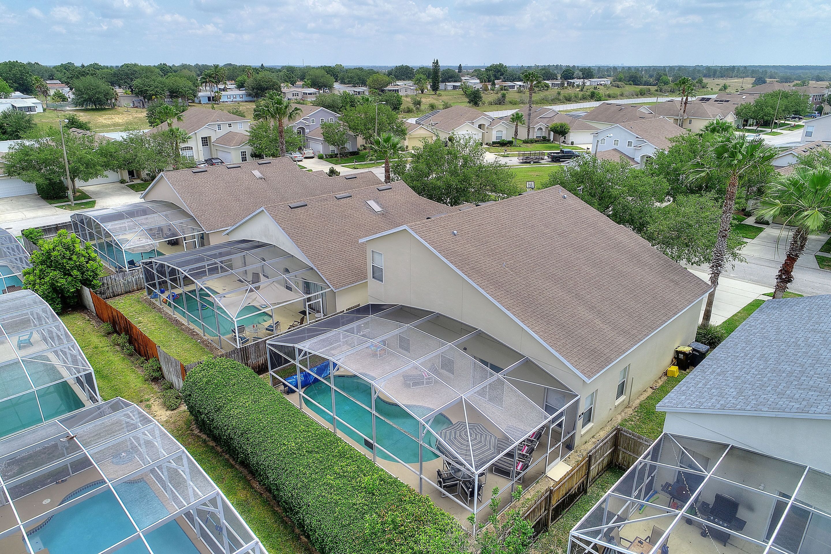 Un barrio residencial con casas, piscina y un patio cubierto.