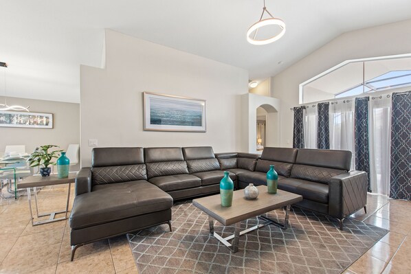 A modern living room with a sectional sofa, a coffee table, and decorative vases.