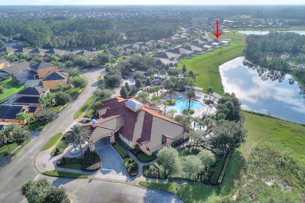 Vista aérea de una zona residencial con casas, piscina y un lago.
