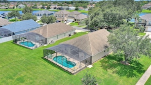Un quartier résidentiel avec des maisons, une piscine et un patio couvert.