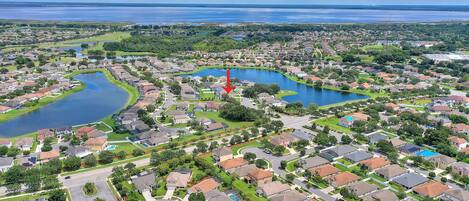An aerial view of a residential area with multiple lakes, houses, and a golf course.