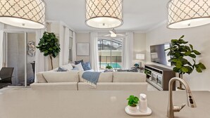 Ein modernes Wohnzimmer mit einer Couch, einem Couchtisch und Pendelleuchten.