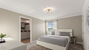 A bedroom with a bed, bedside table, and a small potted plant.