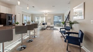 A spacious living area with a kitchen, dining area, and seating with modern furniture.