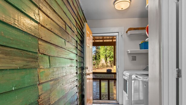 A narrow hallway with wooden walls and a tiled floor leading to a door with a view of a balcony. - Lenoir Cottage w/ covered patio and fire pit! (Athens)
