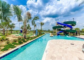 A swimming pool with a water slide, palm trees, and a clear sky. - Duck House at Storey Lake by Shine Villas #992 (Kissimmee)