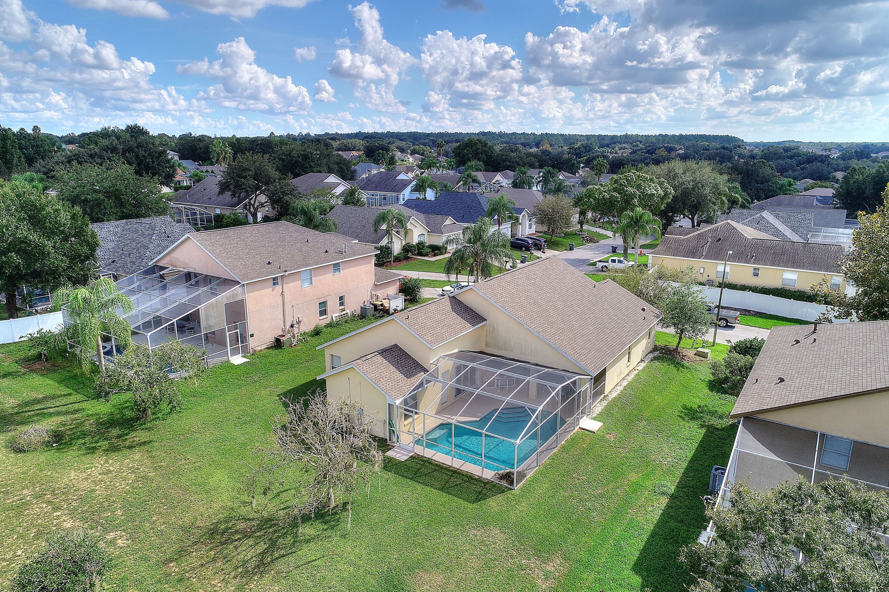 A residential area with houses, a swimming pool, and a large glass-enclosed structure.
