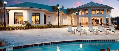 Un resort con piscina, sillas de descanso y un área de patio techada.