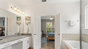 A modern bathroom with a large mirror, a bathtub, and a shower area. - Breathe Easy at Solterra Resort by Shine Villas 706 (Davenport)