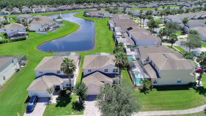 A residential area with houses, a body of water, and a clear sky.