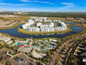 A large, circular hotel complex with multiple buildings, a central water feature, and a swimming pool area. - Star Hideaway at Storey Lake by Shine Villas #716 (Kissimmee)