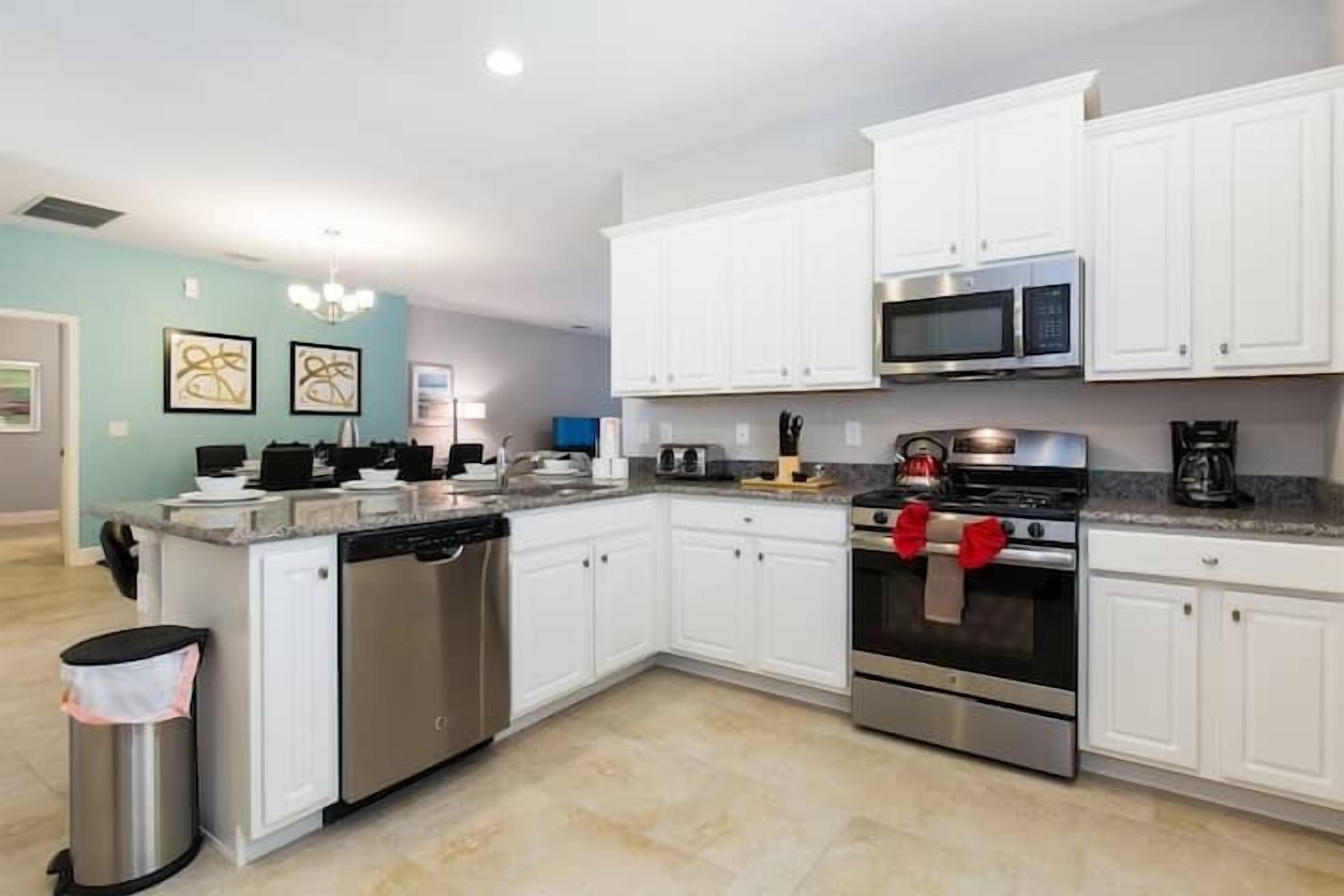 A modern kitchen with white cabinets, stainless steel appliances, and a dishwasher.