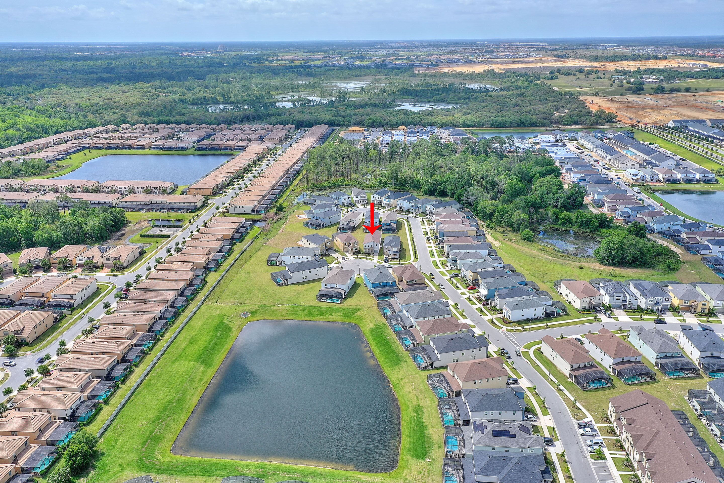 A residential area with multiple housing units, a central road, and a large body of water.