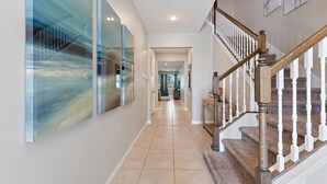 A hallway with a staircase leading to a second floor. - Rebel Flamingo @ Solara Resort by Shine Villas 804 (Kissimmee)