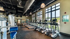 A gym with treadmills, weight machines, and large windows. - Rebel Flamingo @ Solara Resort by Shine Villas 804 (Kissimmee)