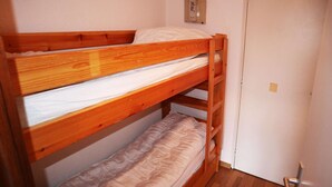 A bunk bed with a wooden frame, a white mattress, and a lower bunk with a beige mattress. - STUDIO N° 0309 LE CAIRN (LES ORRES)