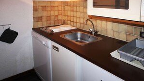 A compact kitchen with a dishwasher, a sink, and a microwave.