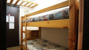 A bunk bed with a wooden frame and floral bedding.