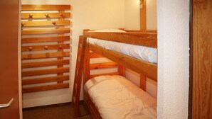 A bunk bed with a wooden headboard and a lower bunk. - APARTMENT N° 407 LE CAIRN (LES ORRES 1650)