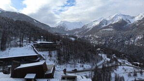 A snow-covered mountain landscape with a lodge featuring multiple buildings, a ski lift, and a winding road. - APARTMENT N° 407 LE CAIRN (LES ORRES 1650)