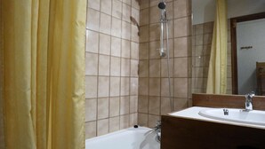 A bathroom with a bathtub, a sink, and a shower. - COEUR STATION LES ORRES - Res. CAIRN - Studio 4 pers (LES ORRES 1650)