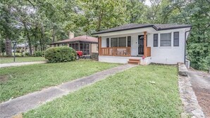A single-story house with a front porch, a small front yard, and a pathway leading to the entrance.