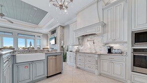 A spacious kitchen with a large island, built-in appliances, and a view to the outdoors. - Large Private Home Sleeping 16 On Cotton Bayou (Orange Beach)