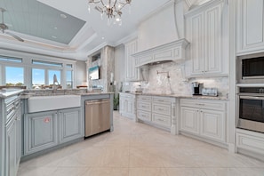 A spacious kitchen with a large island, built-in appliances, and a view to the outdoors.