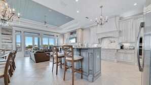 A spacious kitchen with a large island, bar stools, and a dining area with a sofa and chairs. - Large Private Home Sleeping 16 On Cotton Bayou (Orange Beach)