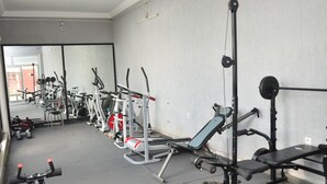 A gym with various exercise equipment, including treadmills, weight machines, and a bench. - Luxury Palace (Lomé)