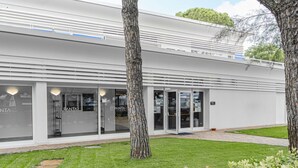Un bâtiment moderne doté de grandes fenêtres en verre et d’une pelouse bien entretenue.