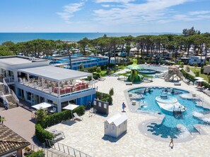 Ett semesterhotell med poolområde, utomhusservering och utsikt över havet.