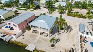 Une propriété située en bord de mer, comprenant une grande maison, un quai et une piscine.