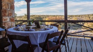 An outdoor dining area with a table set for four, overlooking a natural landscape. - Selah Springs Ranch- Large Family Reunion/Retreat Ranch on the River- Sleeps 60 (Brady)