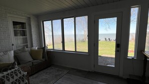 En rummelig stue med et stort vindue, en sofa og et tæppe.