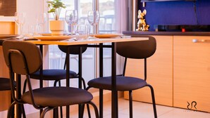 Een eethoek met een tafel voor vier personen, stoelen en een potplant.