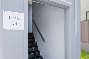 A staircase leading to a door with a sign indicating 'Units 1, 4'. - Ocean Views Beachfront Escape at Boat Harbour (Boat Harbour)