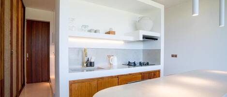 A modern kitchen with white cabinetry, a large island, and built-in shelves.