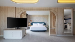 Una habitación de hotel moderna con una cama grande, un televisor y un armario de madera.