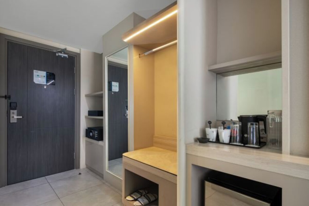 A modern bathroom with a mirror, a sink, and a shelf with toiletries.