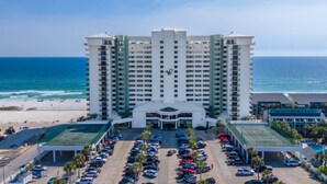 A high-rise hotel with a central entrance, parking lot, and a view of the beach and ocean. - Penthouse, Stunning view, beach front, private (Panama City Beach)