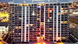 A multi-story hotel with balconies, a swimming pool, and a parking area. - Penthouse, Stunning view, beach front, private (Panama City Beach)